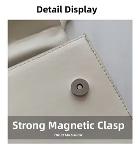 Gros plan sur le fermoir magnétique et les coutures d'un sac en similicuir crème