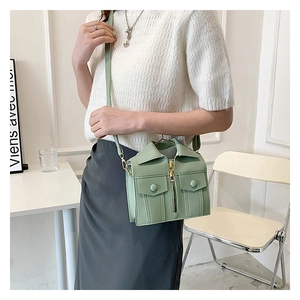 Detail of light green jacket-shaped mini bag with golden zipper and fashion lapels