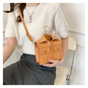 Detail of creative orange jacket-shaped mini crossbody bag with zipper and gold hook