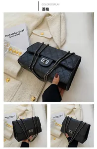 Close-up of black quilted chain bag with lychee texture leather and metallic clasp