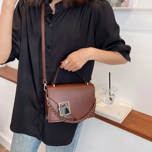 Brown leather crossbody bag with V-shaped flap and decorative chain for women
