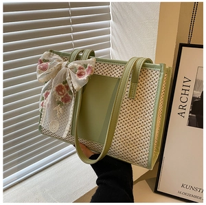 Dettaglio borsa tote in paglia con grande fiocco in pizzo e ricami floreali rosa