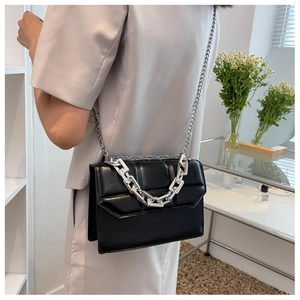 Détail du sac bandoulière matelassé noir avec grosse chaîne en métal argenté et cuir