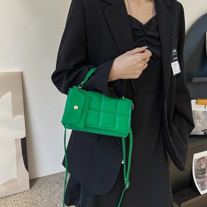 Vibrant green quilted crossbody bag with a small front pouch and adjustable strap