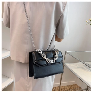 Détail du sac à bandoulière en cuir noir gaufré avec doubles chaînes argentées