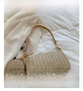 Detailed close-up of woven straw handbag with a detachable round coin purse and slim strap