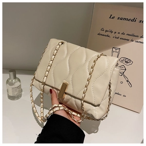 Détail du sac bandoulière matelassé blanc cassé avec chaîne dorée et coutures