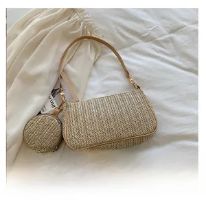 Detail of beige straw shoulder bag with khaki leather trim and matching round coin purse
