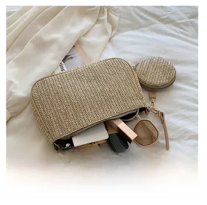 Detail view of khaki straw crossbody bag showing internal capacity for phone and sunglasses