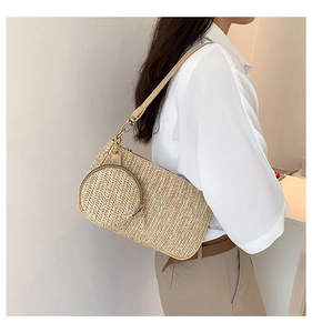 Detail of straw woven shoulder bag and mini coin purse charm with brown leather straps