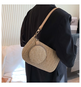 Detail of woven straw shoulder bag with detachable round coin purse and metal clasp