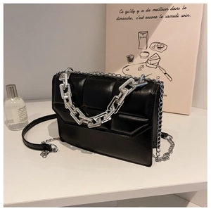 Détail du sac à bandoulière matelassé noir avec chaîne argentée et rabat minimaliste