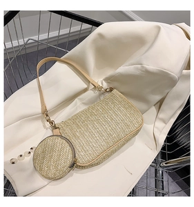 Detail of straw woven shoulder bag with a round coin purse and gold hardware accents