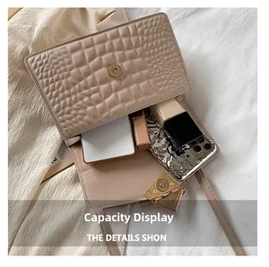 Détail du sac beige texturé montrant l'espace interne pour téléphone et maquillage