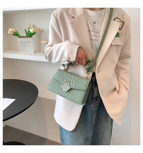 Détail du sac bandoulière vert clair effet crocodile avec poignée froncée et fermoir doré