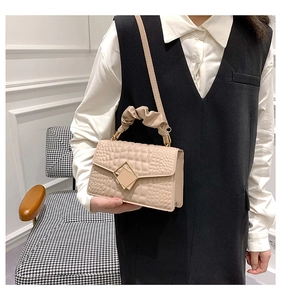 Sac bandoulière beige tendance avec texture crocodile et détail élégant de poignée plissée