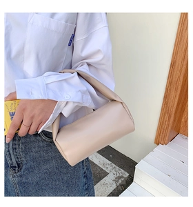 Detail of a creamy white soft PU leather cylindrical handbag with a minimalist pillow design