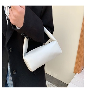 Detail view of a minimalist white matte faux leather rectangular shoulder bag with top zipper