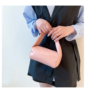 Close-up of a pink mini barrel handbag featuring smooth soft leather and a metal zipper