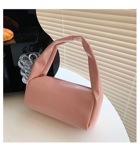 Detail view of pink soft leather handbag featuring a stylish integrated knotted handle