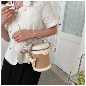 Detail of retro bucket bag with crocodile pattern and scarf-wrapped handle decoration