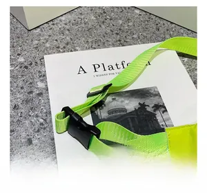 Detail of neon green nylon shoulder strap with a durable black plastic buckle and adjuster