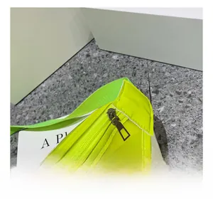 Detail of smooth silver zipper on neon yellow transparent PVC crossbody bag