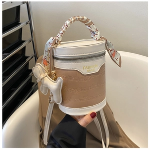 Close-up of retro bucket bag with crocodile texture, silk scarf handle and puppy charm