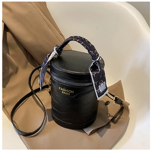 Close-up of black crocodile pattern bucket bag with silk scarf on top handle