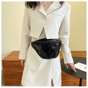 Close-up of black glossy patent leather fanny pack with premium metal zipper detail