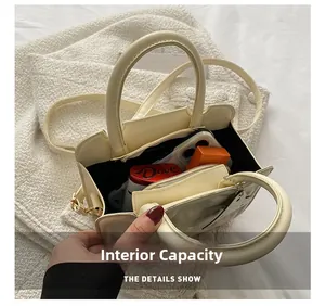 Top view showing the internal capacity of the cream crossbody bag with daily essentials