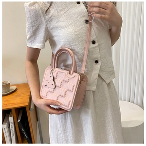 Detailed texture of pink bubble pattern PU leather bag with adjustable strap and handle