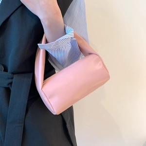 Minimalist soft pink barrel handbag with integrated handle for spring fashion look