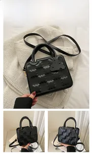 Detail of black waffle-textured handbag featuring chic gold hardware and leather handles