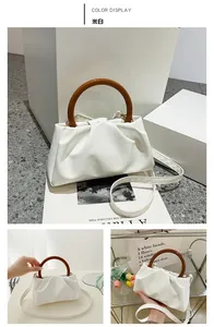 Detail of off-white cloud pleats bag with brown round handle and PU leather texture