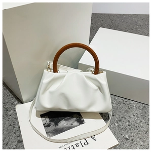 Detail of white pleated cloud bag featuring contrast brown round handle and PU texture
