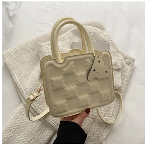 Detail of creative biscuit-shaped handbag with scalloped edges and textured cream faux leather