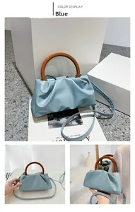 Detail view of light blue pleated cloud bag featuring a unique amber acrylic handle