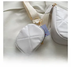 Detail der weißen gesteppten Handtasche mit abnehmbarer runder Münztasche und Goldzipper