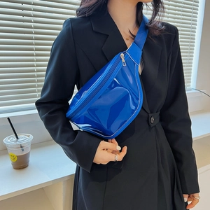 Vibrant electric blue glossy chest bag for women in crescent shape on black blazer