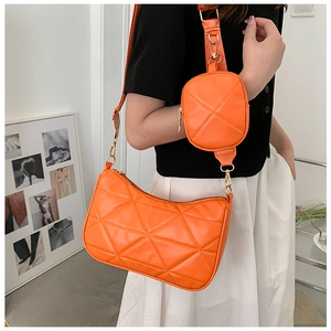 Detail der orangefarbenen Stepptasche mit Rautenmuster und kleinem runden Münzetui