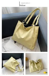 Detail view of yellow faux leather tote bag with silver metal rings and minimalist design