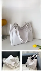 Detail of beige minimalist PU leather tote bag showing silver ring handle connection