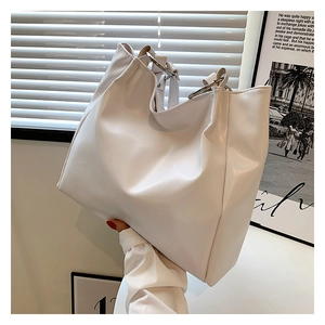 Detail of white soft PU leather tote bag with minimalist metal ring hardware handle