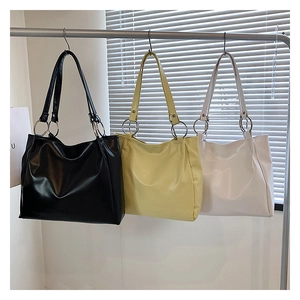 Detailed comparison of large tote bags in black, soft yellow, and off-white faux leather