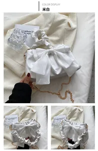 Dettaglio borsa in raso bianco crema con fiocco grande e manico plissettato