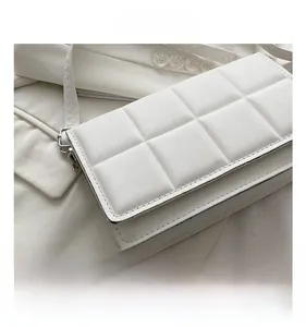 Close-up of white crossbody bag showing detailed checkered texture and silver hardware