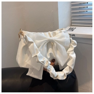 Dettaglio della borsa a tracolla bianca a pieghe con fiocco in organza e fibbie dorate