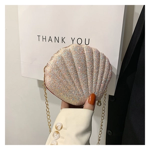 Detailed macro view of sparkling pink sequin shell bag with gold chain and pearl charm
