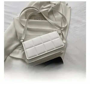 Quilted white crossbody bag detail showing size scale with a smartphone comparison